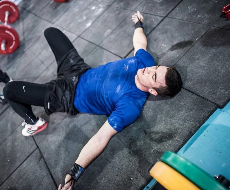 Un sportif épuisait qui est allongé sur le dos pour récupérer après un WOD