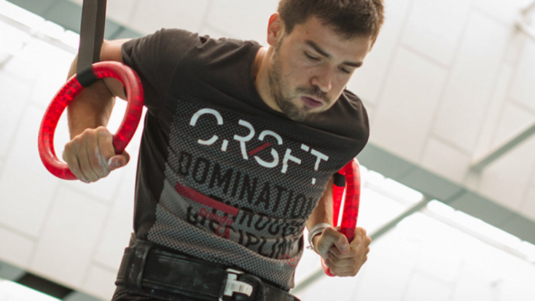 Un athlète qui réalise des stricts dips aux anneaux lors d'une séance de crossfit